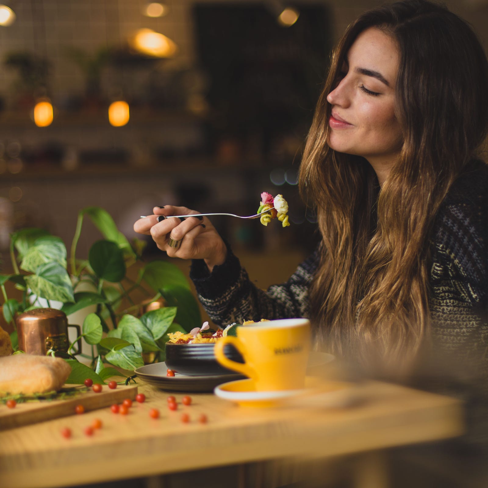 Vrouw geniet van heerlijk eten met korting in haar favoriete restaurant.